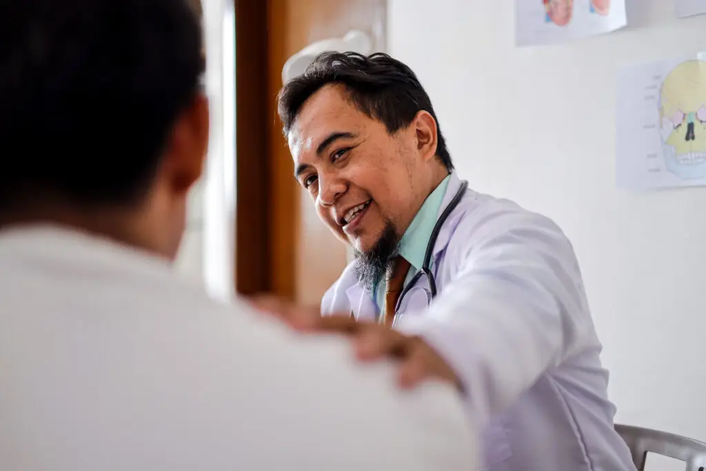 Doctor Touching Patient's Shoulder, Expressing Empathy and Support at Medical Appointment